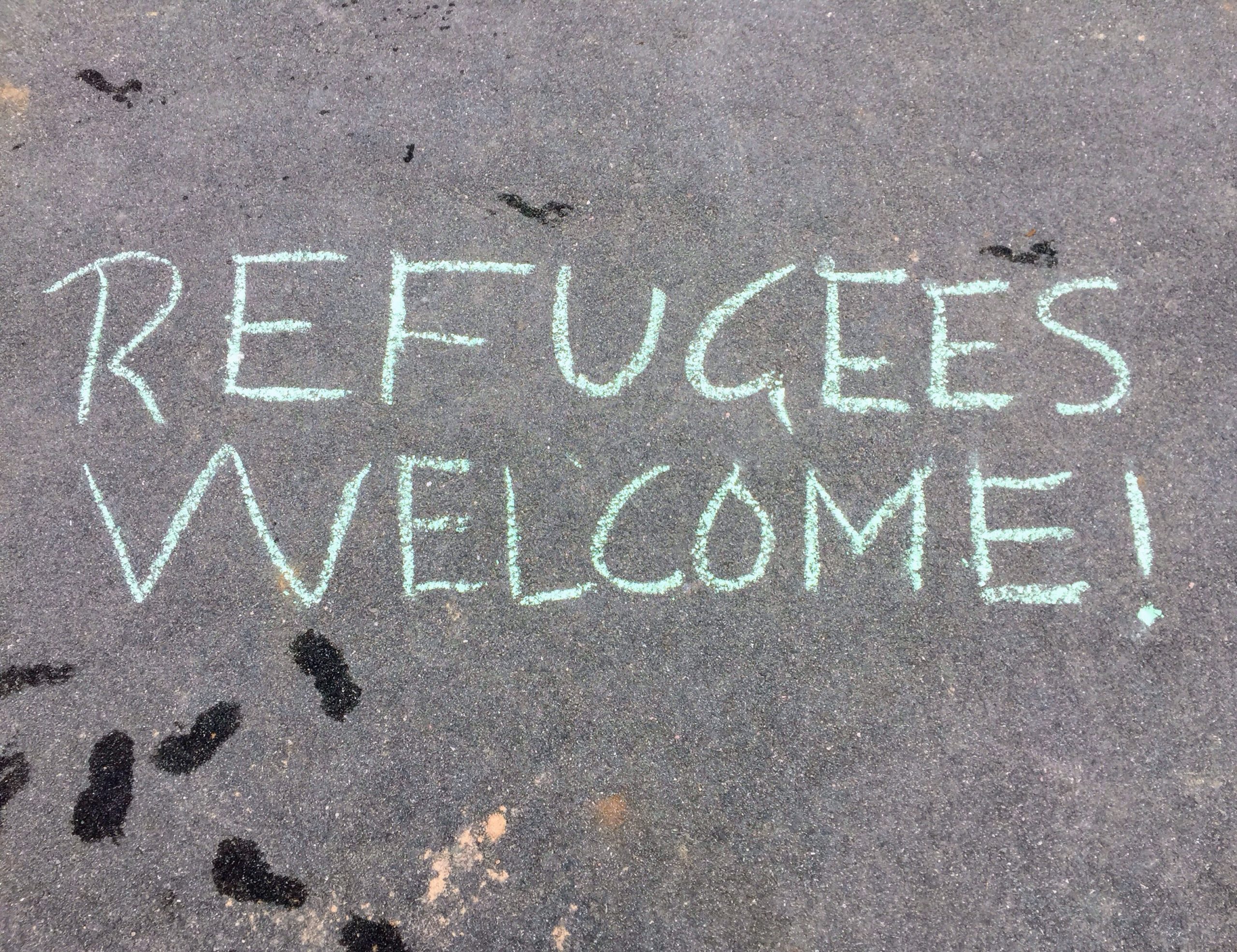 Refugees welcome written in chalk on the ground