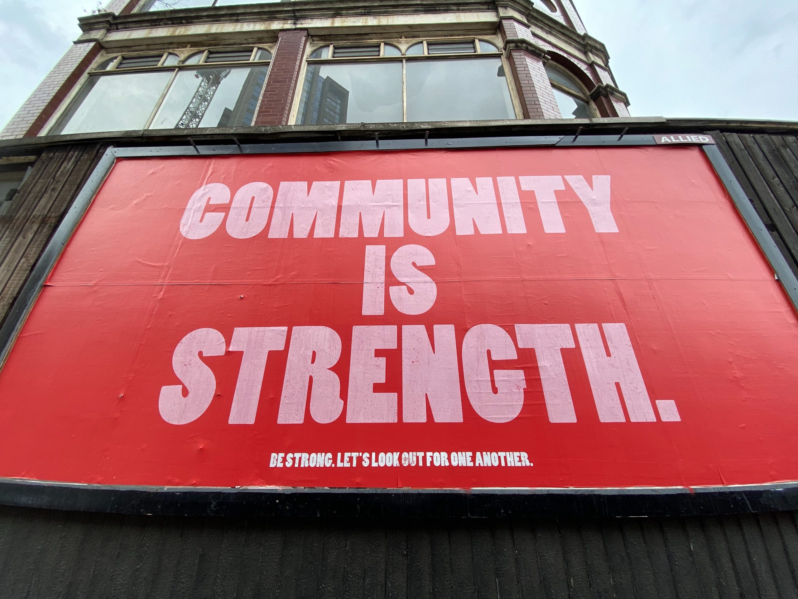 Billboard with 'Community is strength' written on it